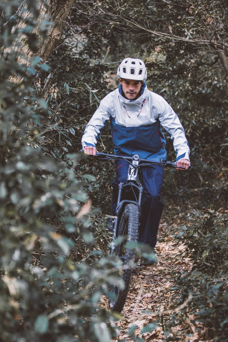 a man riding a bike through a forest