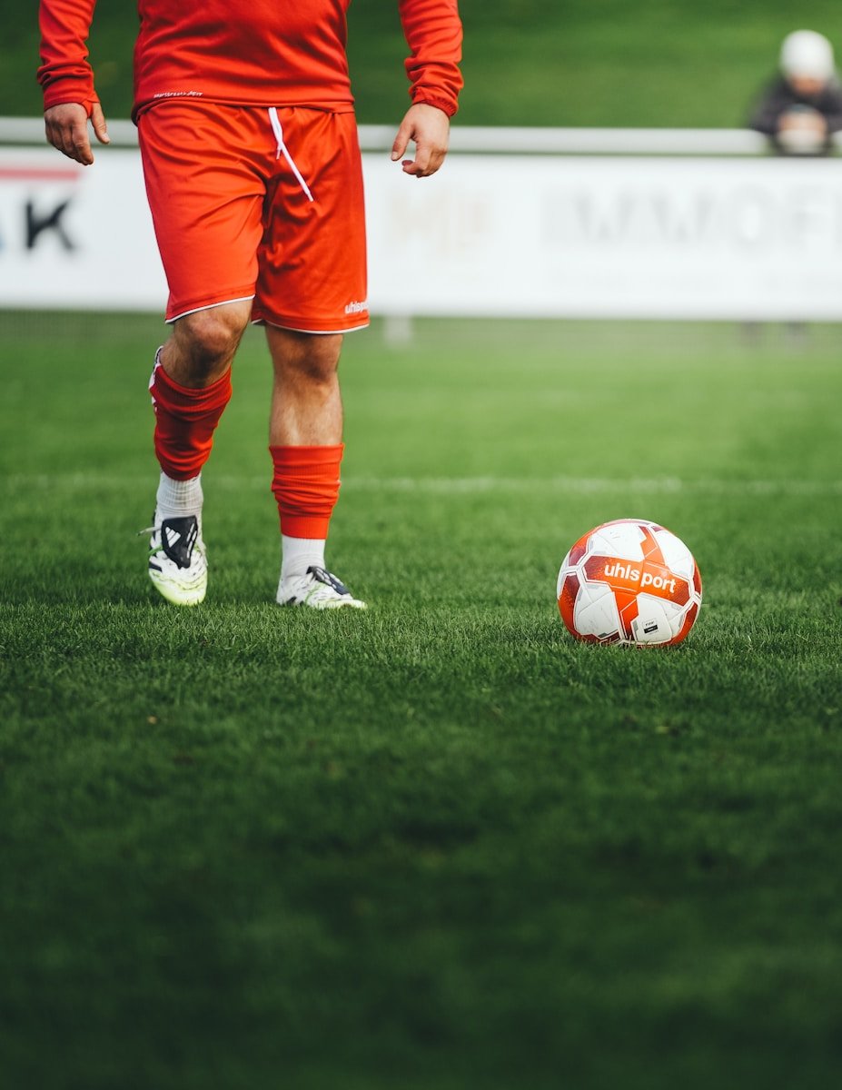 Soccer player standing near a ball on grass