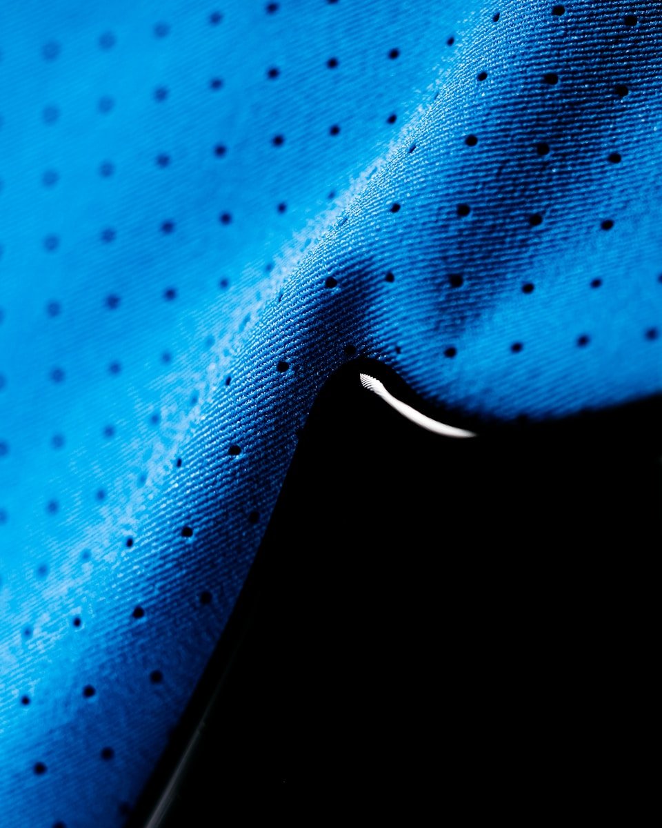 a close up of a blue shirt with black dots